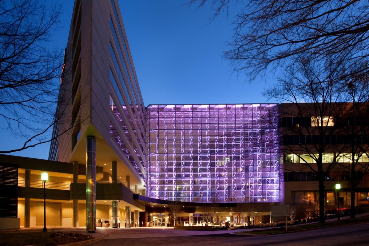 Hyatt Regency Greenville exterior at dusk with its lit glass atrium