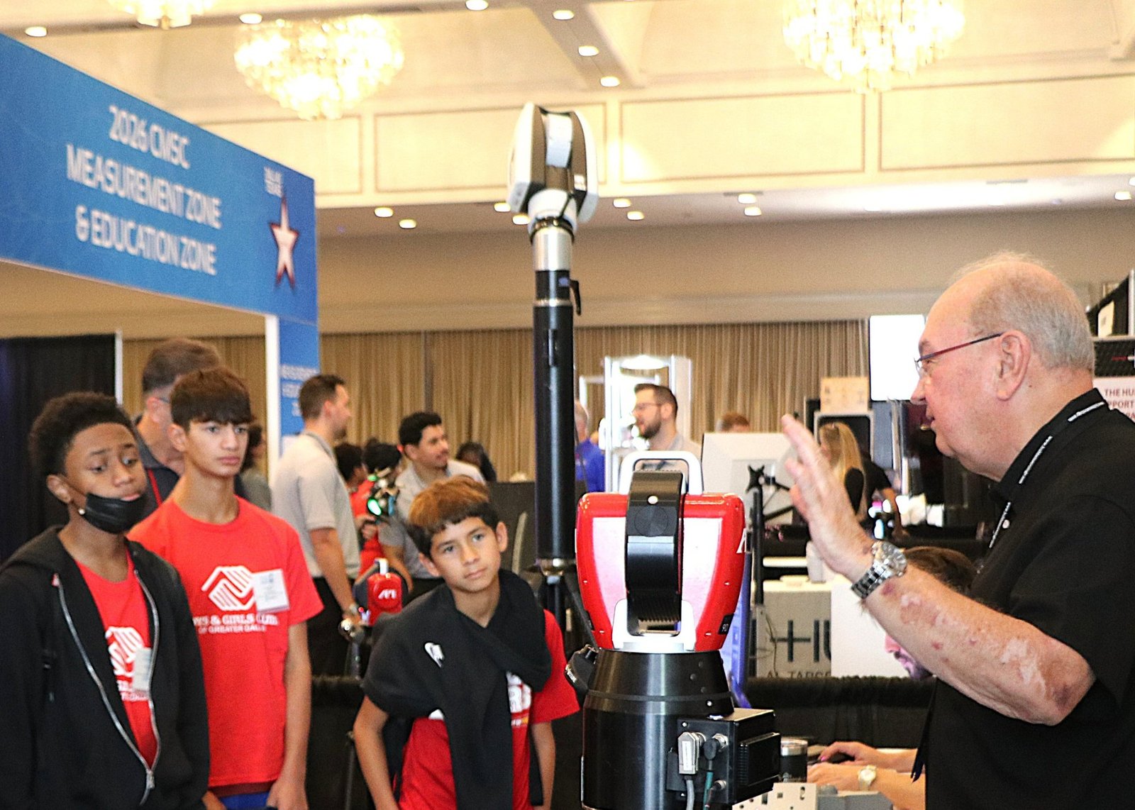 Students from the Boys & Girls Clubs of Greater Dallas watching a presenter demonstrate a laser tracker at the CMSC Measurement Zone