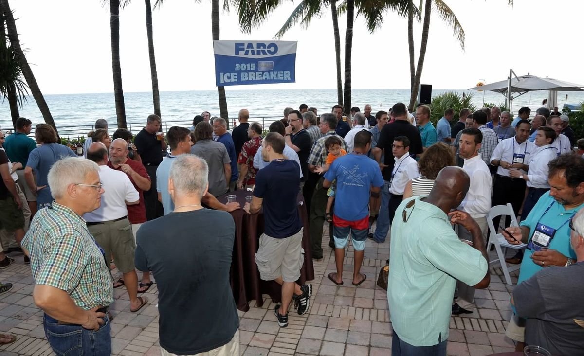 Attendees networking at the CMSC Ice Breaker reception on an oceanfront patio