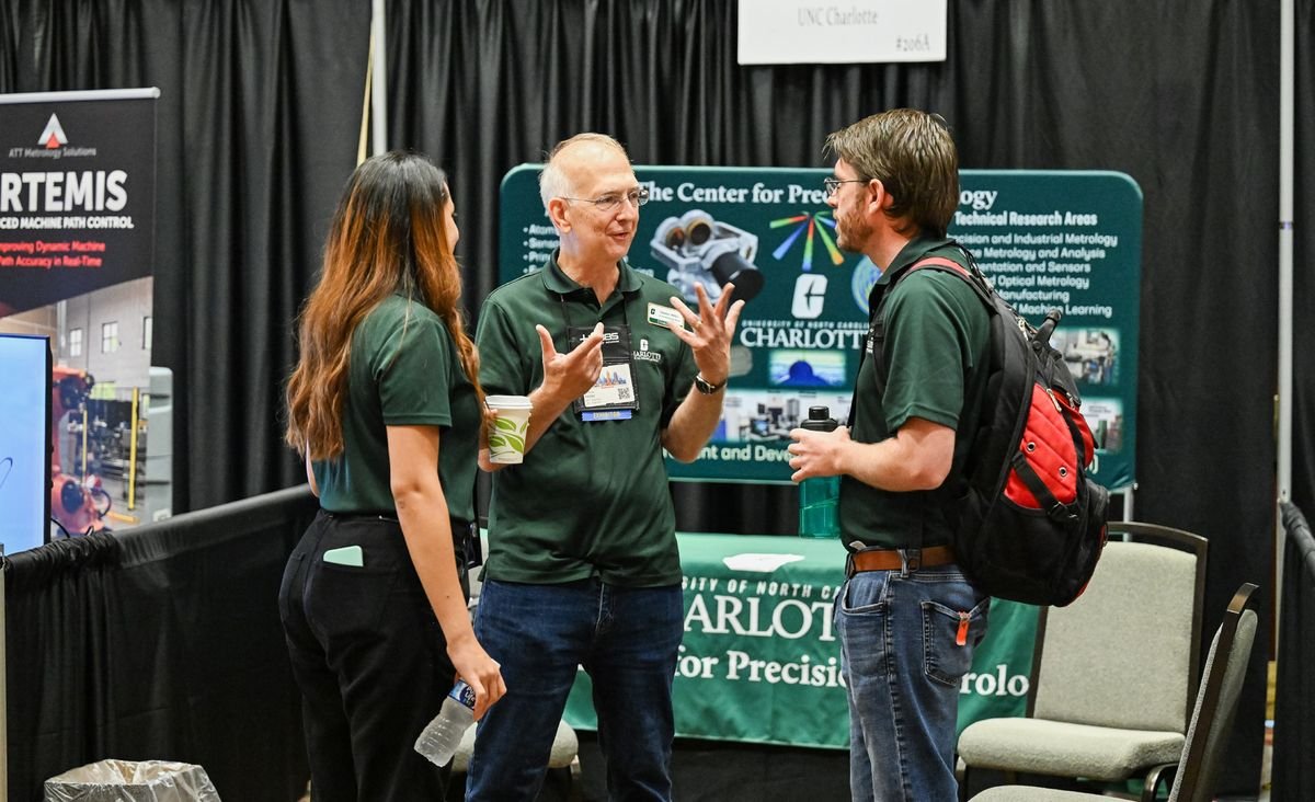 UNC Charlotte Center for Precision Metrology Booth Representatives of the UNC Charlotte Center for Precision Metrology talking with a visitor at their CMSC booth