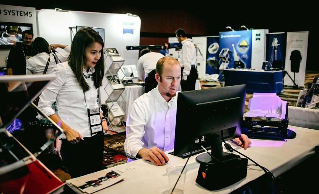 Young Metrologists Using Measurement Software Young metrology professionals working with measurement software at a CMSC exhibit booth